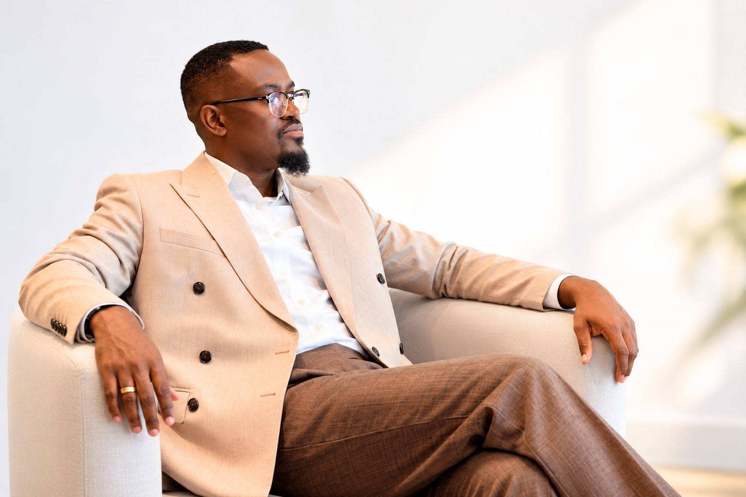 Jean Kabongo Kinduelo seated in a beige suit